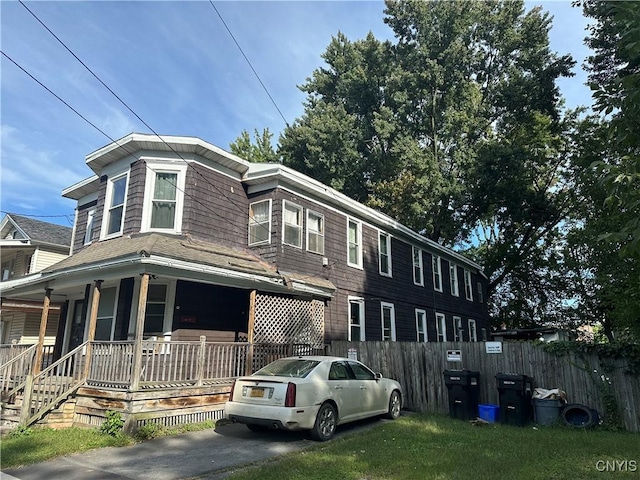 view of front of home featuring a porch and fence