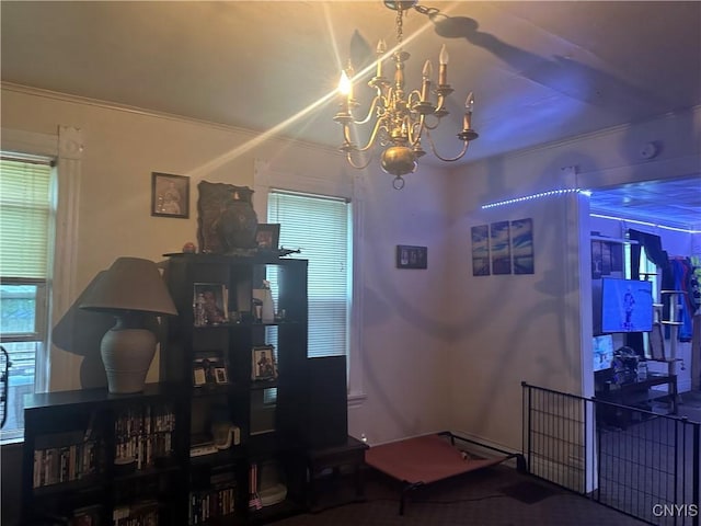 living room with crown molding, plenty of natural light, and a notable chandelier