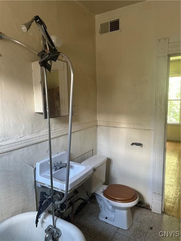 bathroom featuring a sink, toilet, and visible vents