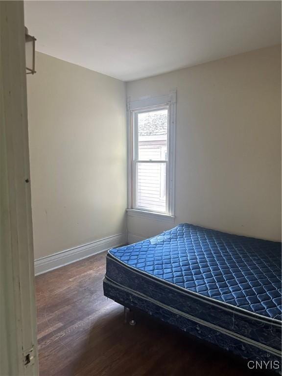 bedroom featuring baseboards and wood finished floors