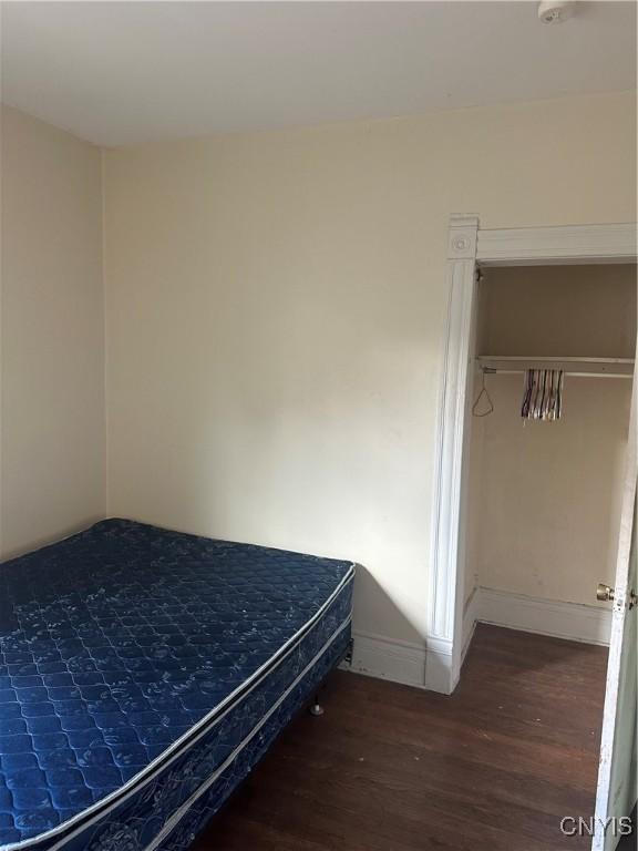 bedroom featuring baseboards and wood finished floors