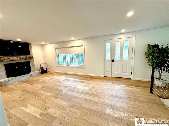 foyer with a premium fireplace, baseboards, recessed lighting, and light wood-type flooring