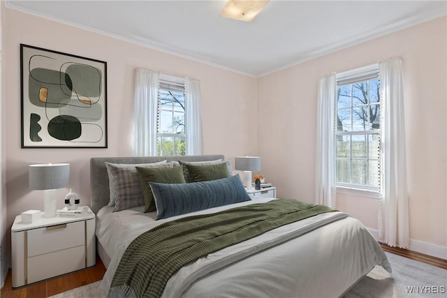 bedroom featuring crown molding and wood finished floors