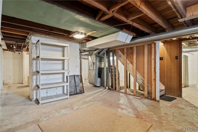 unfinished below grade area featuring heating unit and stairway