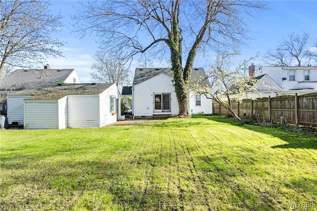 view of yard featuring fence and an outbuilding