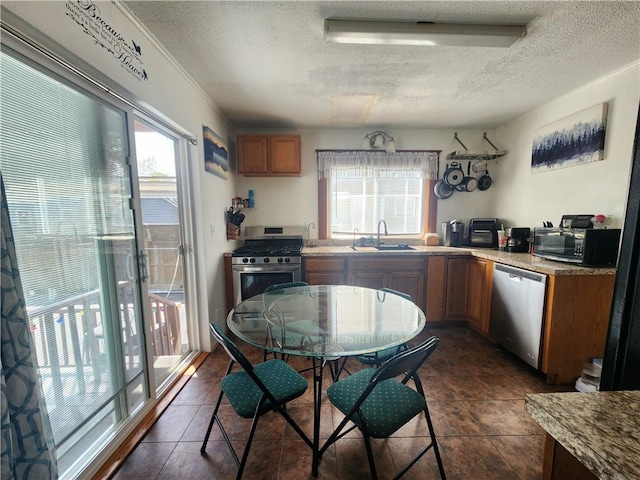 kitchen featuring a sink, plenty of natural light, stainless steel appliances, and a textured ceiling