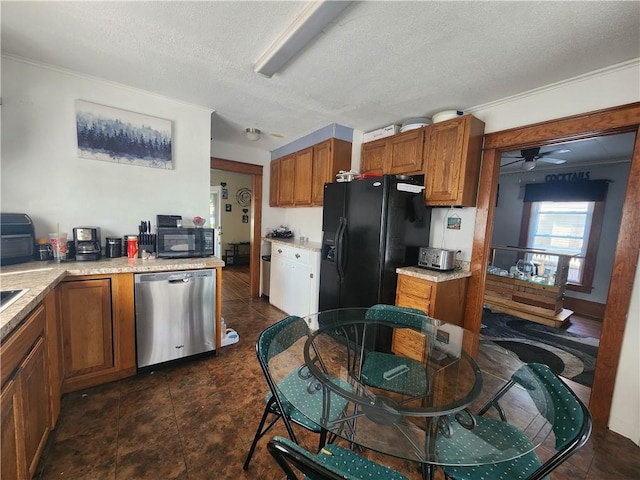 kitchen with brown cabinetry, a ceiling fan, a textured ceiling, light countertops, and black appliances