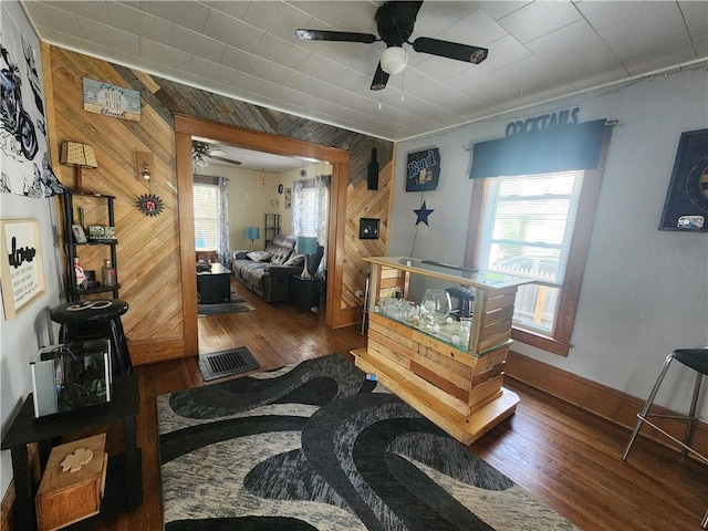 interior space with wood finished floors, wooden walls, and a wealth of natural light