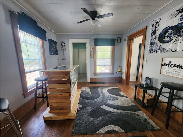 interior space featuring dark wood-type flooring, baseboards, and ceiling fan