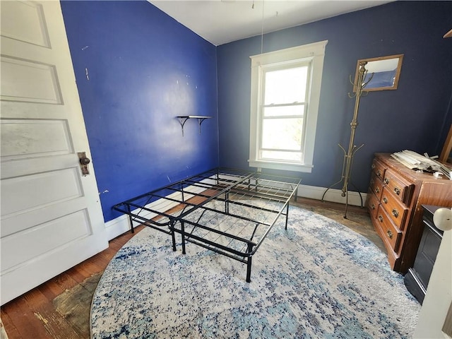 bedroom featuring baseboards and wood finished floors