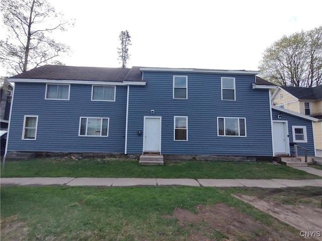 view of property featuring a front lawn and entry steps