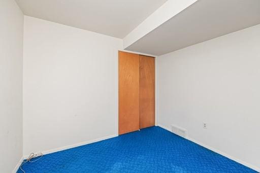 carpeted spare room with baseboards and visible vents