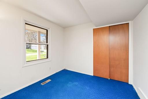 unfurnished bedroom featuring carpet floors, baseboards, and visible vents