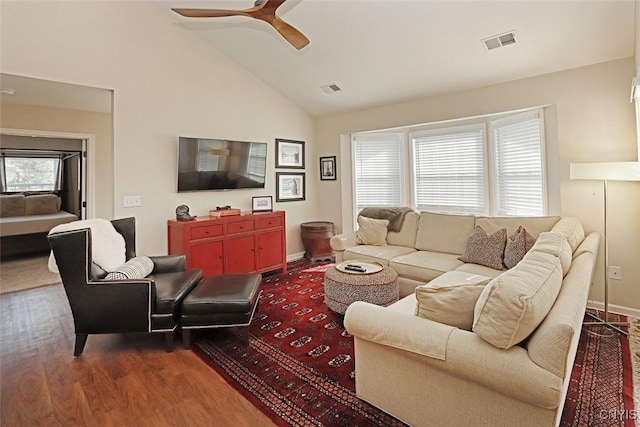 living area featuring a ceiling fan, high vaulted ceiling, visible vents, and dark wood-style floors