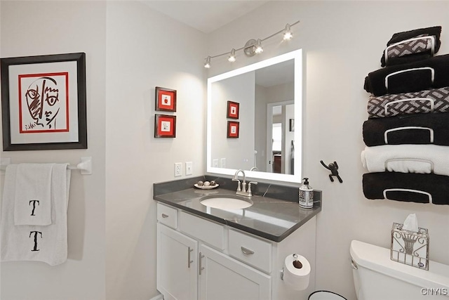 half bathroom with vanity and toilet
