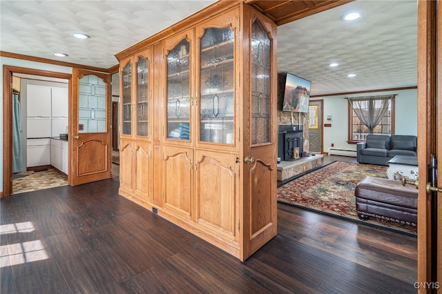 interior space featuring crown molding, a wood stove, dark wood-type flooring, and a baseboard radiator