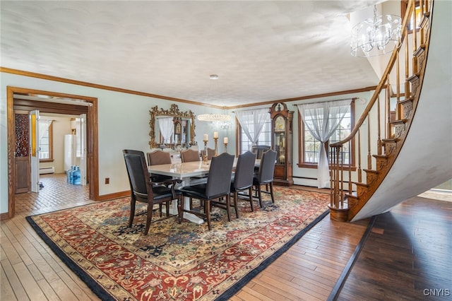 dining space with an inviting chandelier, ornamental molding, hardwood / wood-style floors, baseboards, and stairway