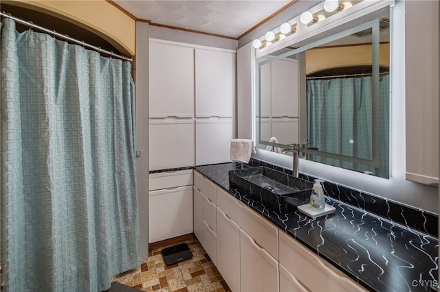 full bath with stone finish flooring, ornamental molding, and vanity