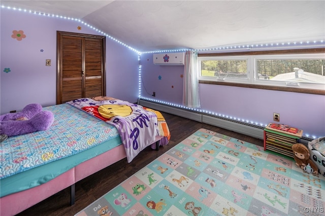 bedroom featuring a closet, baseboard heating, vaulted ceiling, and wood finished floors