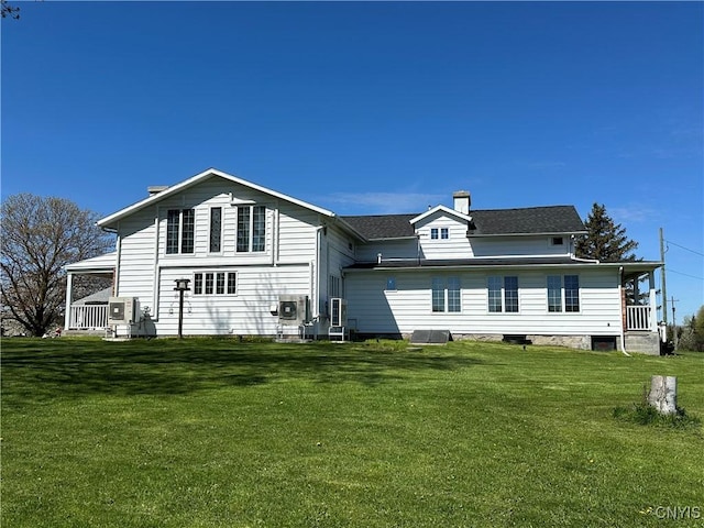 rear view of property with a lawn and a chimney