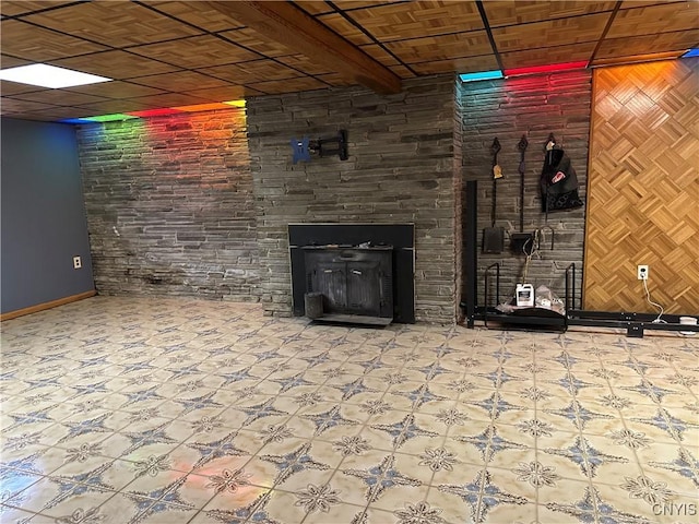 finished basement featuring baseboards, tile patterned floors, and a fireplace