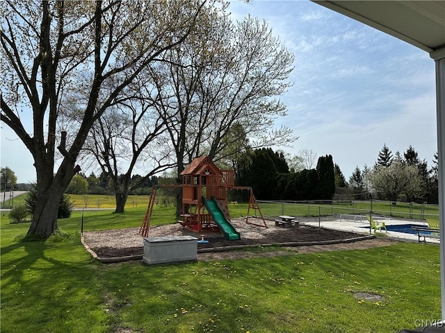 community play area with a yard and fence