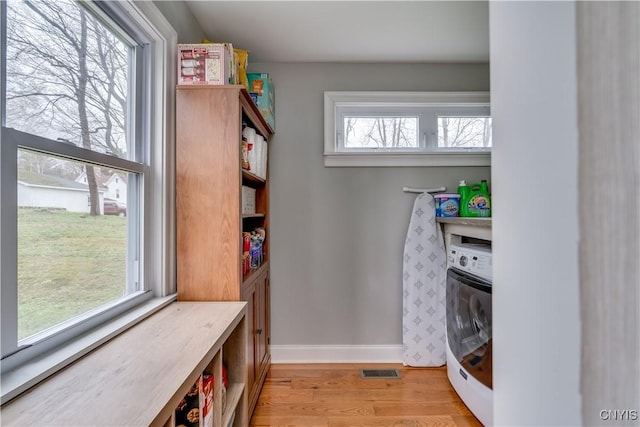 washroom featuring laundry area, light wood finished floors, baseboards, washer / dryer, and visible vents