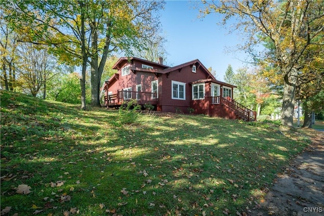 view of property exterior with a lawn, a wooden deck, and a chimney