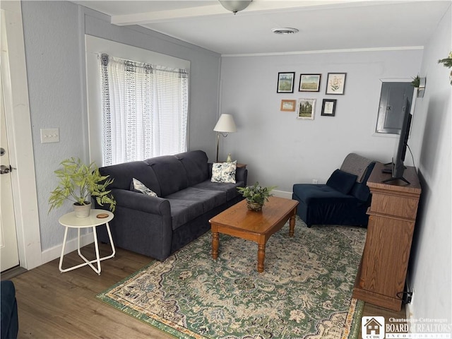 living area with visible vents, baseboards, and wood finished floors