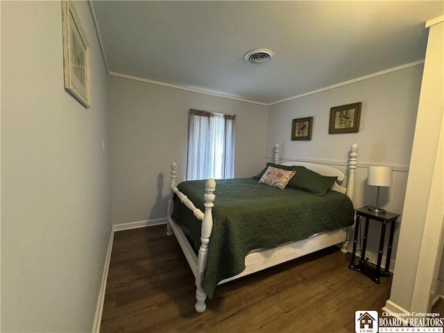 bedroom with visible vents, ornamental molding, baseboards, and wood finished floors