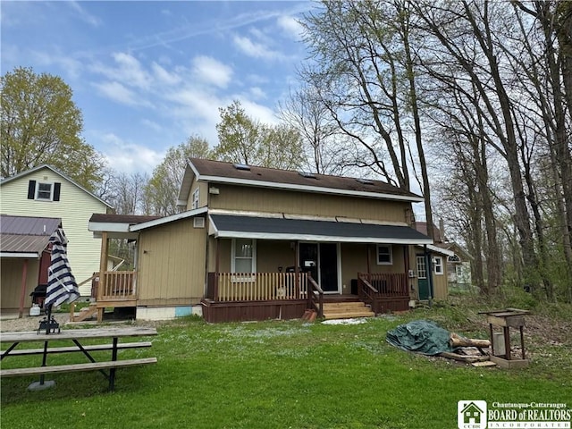 rear view of property with a yard and covered porch