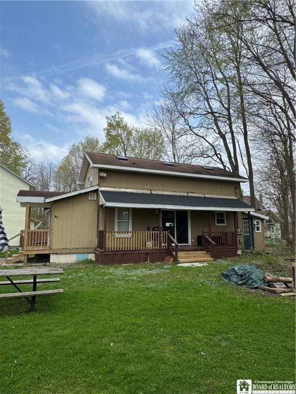 back of house with covered porch and a yard