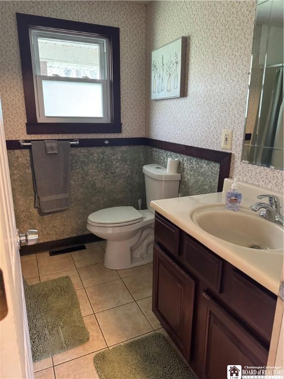full bath with visible vents, tile patterned flooring, vanity, toilet, and wallpapered walls