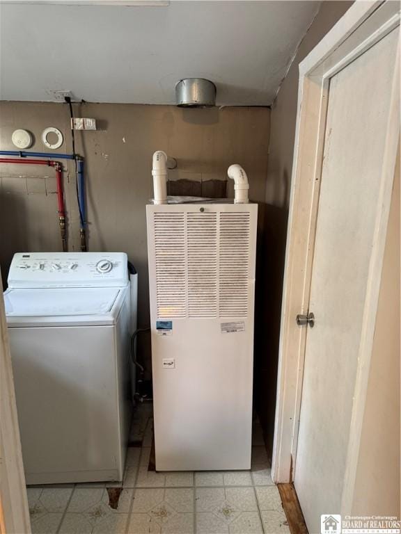 clothes washing area featuring laundry area, a heating unit, and washer / dryer