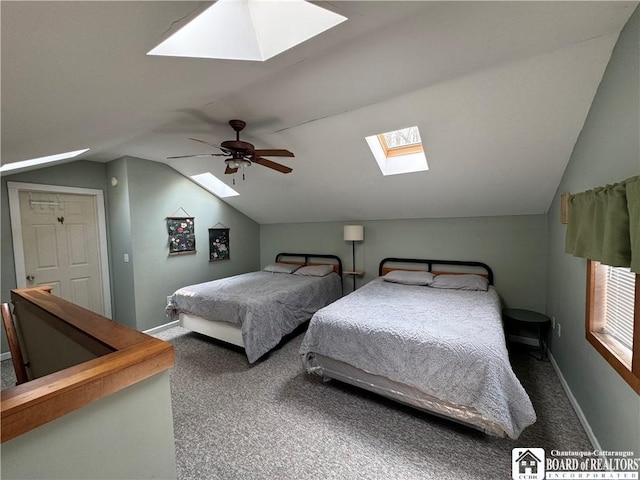 bedroom featuring vaulted ceiling with skylight, baseboards, ceiling fan, and carpet