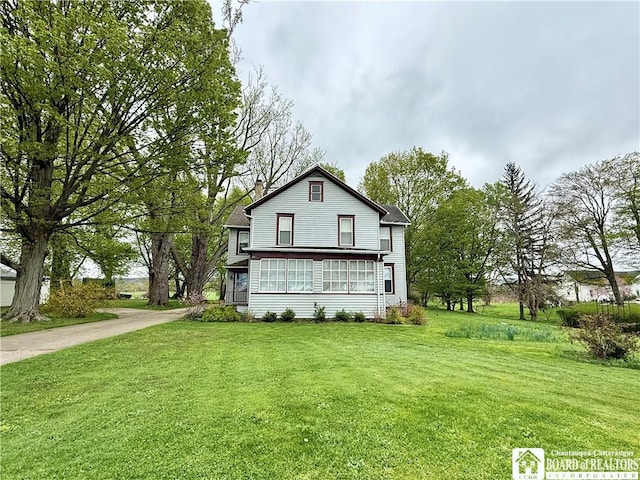 view of side of home featuring a lawn and a sunroom