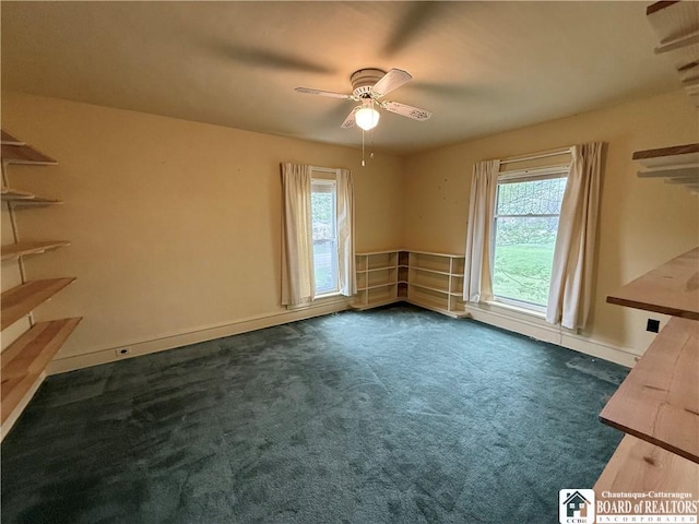 spare room featuring ceiling fan, baseboards, and dark colored carpet