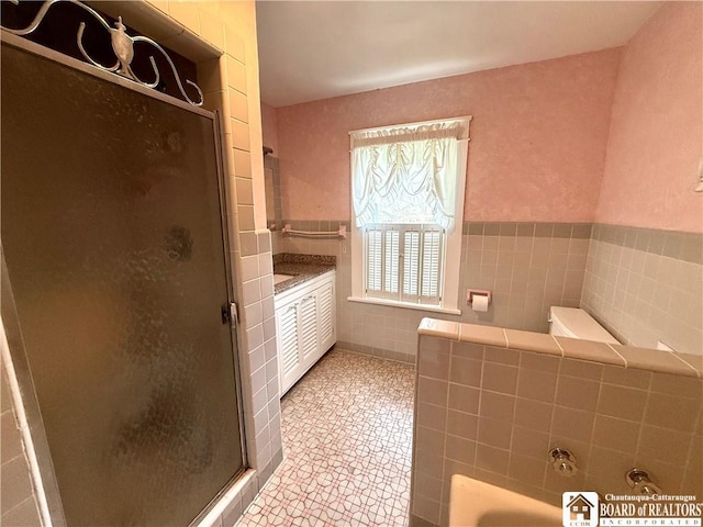 full bathroom featuring a garden tub, tile patterned floors, a stall shower, and tile walls