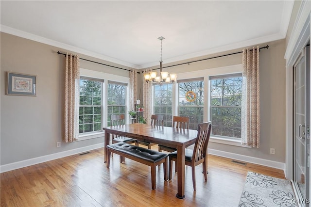 dining space with crown molding, baseboards, a chandelier, and visible vents