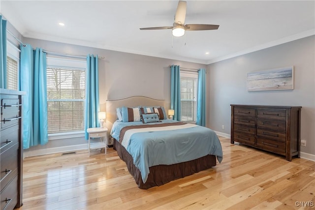 bedroom with baseboards, visible vents, multiple windows, and light wood finished floors