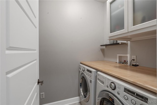 clothes washing area featuring baseboards and independent washer and dryer