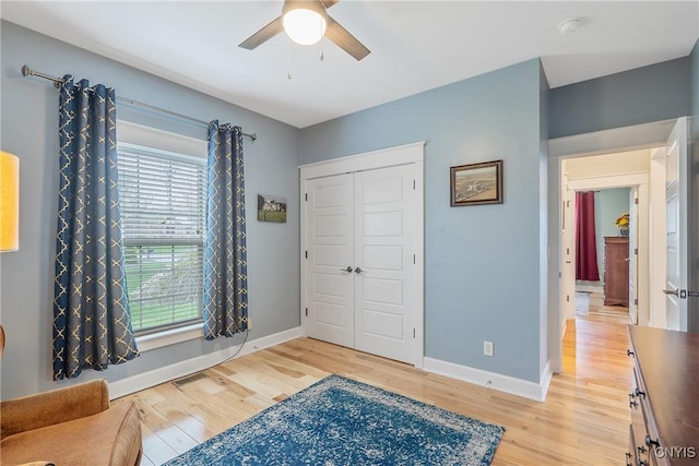 bedroom with light wood-style floors, baseboards, and a closet