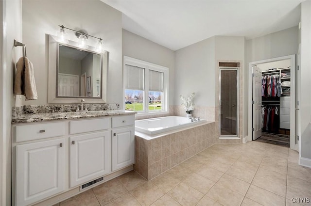 bathroom with a stall shower, visible vents, tile patterned flooring, and a garden tub