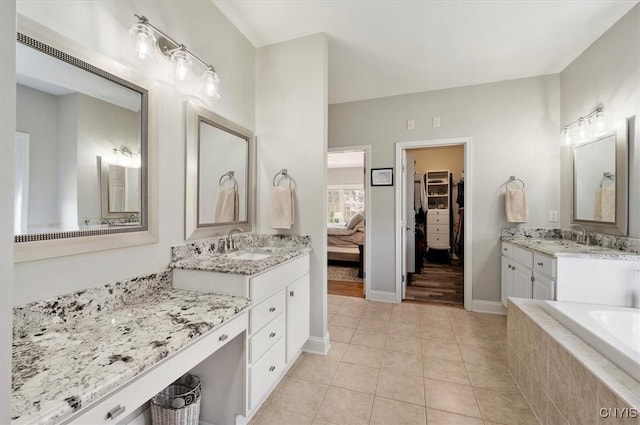 bathroom with tile patterned flooring, a sink, baseboards, and two vanities