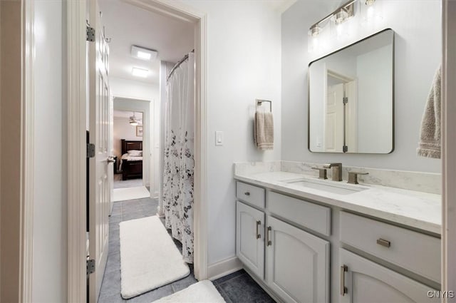bathroom with baseboards, tile patterned flooring, and vanity