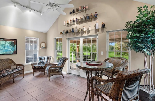 interior space with track lighting, baseboards, high vaulted ceiling, tile patterned floors, and a ceiling fan