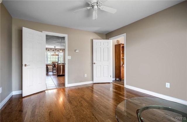 unfurnished bedroom featuring baseboards, ceiling fan, and wood finished floors