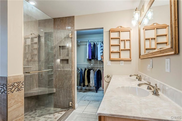 bathroom featuring a sink, a walk in closet, and a shower stall