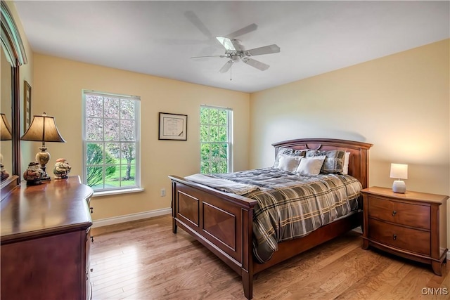bedroom featuring light wood-type flooring, a ceiling fan, and baseboards