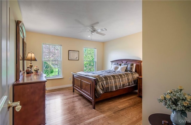 bedroom featuring baseboards, a ceiling fan, and wood finished floors